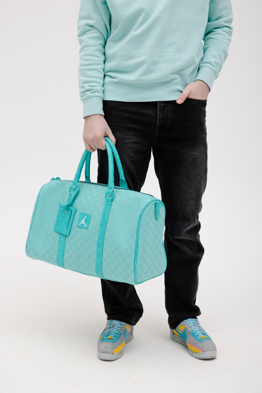 Бирюзовая сумка Jordan Duffle в руке